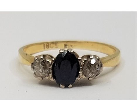 An 18ct. gold, sapphire and diamond and ring, set mixed oval cut sapphire to centre flanked by single old cut diamond to eith