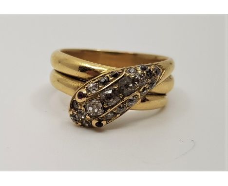 An 18ct. gold and diamond snake ring, the head pave set graduated old and rose cut diamonds, with cabochon pink stone set eye