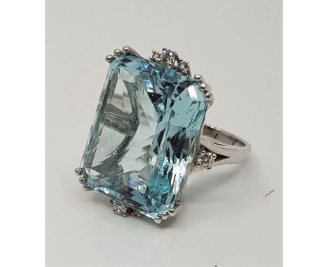 A precious white metal, aquamarine and diamond dress ring, set large rectangular step cut aquamarine (estimated weight approx