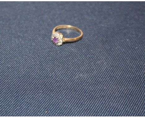 An 18ct. gold, amethyst and diamond ring, claw set round cut amethyst to centre within millegrain border set round cut diamon