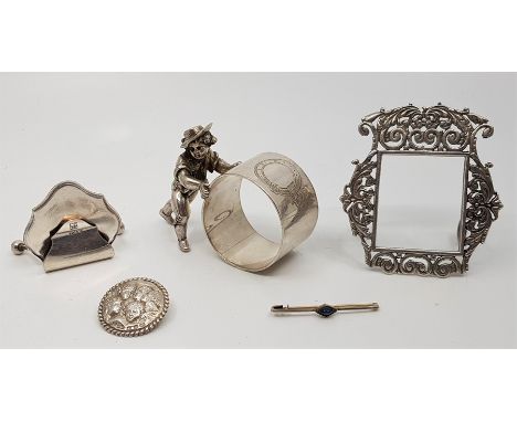 A collection of small silver items, to include; a novelty white metal napkin ring fashioned as a young boy rolling a hoop (wh