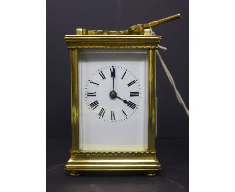A 20th century French gilt brass carriage clock, the enamel dial with Roman numerals, having key, H.14 W.9 D.8cm 