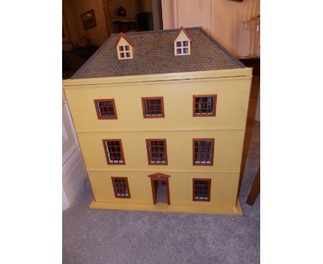 A yellow painted modern wooden doll's house with contents, having hipped roof with two dormer windows, the front opening as a