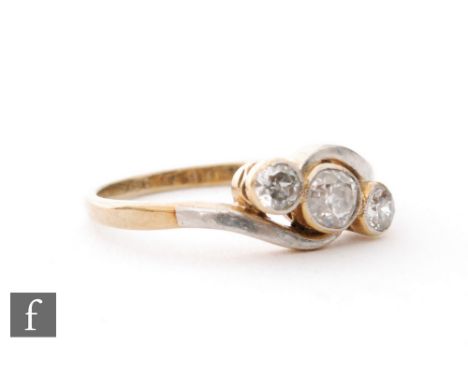 An early 20th Century diamond three stone ring, millgrain set old cut stones to a slight twist, ring size L. 