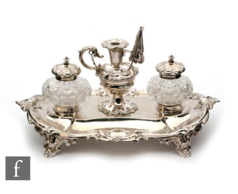 A hallmarked silver oval desk stand with twin clear cut glass wells flanking central miniature chamber stick and snuffer, the