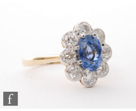 An 18ct sapphire and diamond cluster ring, central cornflower blue sapphire within a border of eight old cut millgrain set st