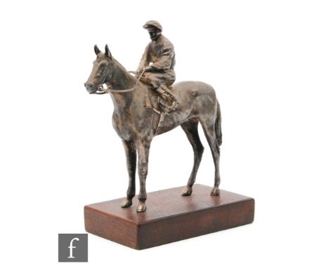 A hallmarked silver study of a standing horse and jockey mounted to a rectangular wooden base, height 17cm, total weight 19.5