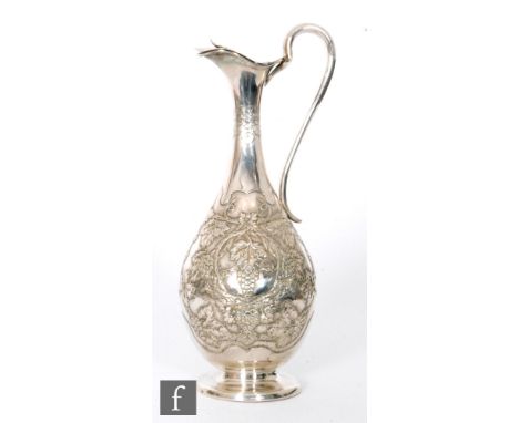 A Portuguese silver wine flagon embossed with fruiting vine and terminating in elongated scroll handle, height 34cm, weight 2