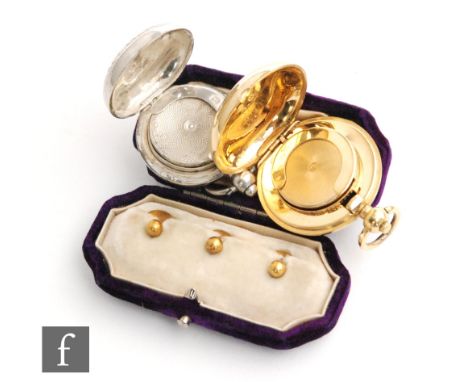 A hallmarked silver circular sovereign case, Birmingham 1903, with another gilt metal example and three 15ct dress studs. 