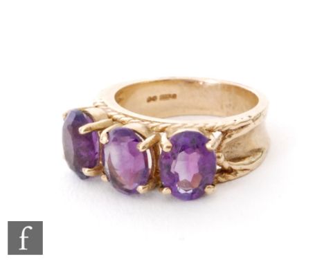 A 9ct hallmarked amethyst three stone ring, claw set oval stones to a rope twist detailed head, weight 5.2g, ring size K. 