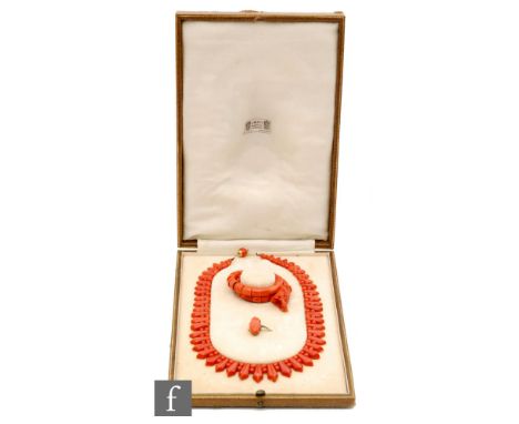 An Art Deco Liberty &amp; Co carved coral suite of jewellery comprising a necklet, sprung bangle and a ring, all within origi