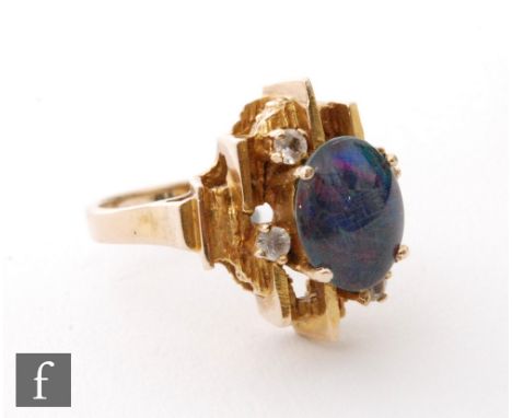 A 9ct opal doublet and diamond abstract ring, central oval doublet detailed with four diamonds to a stepped bark effect head,