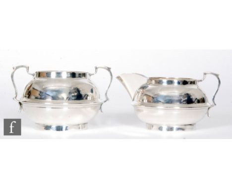 A hallmarked silver cream and sugar basin of plain circular form with central raised band detail, total weight 6.5oz, London 