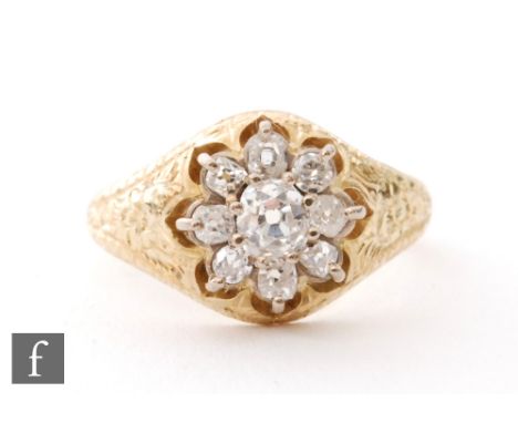 An 18ct hallmarked diamond daisy cluster ring, nine claw set old cut stones to a foliate engraved head, ring size N 1/2. 