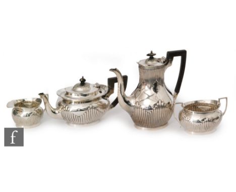 A hallmarked silver four piece boat shaped tea set with part fluted decoration, total weight 52oz, Sheffield 1904 and 1911, M