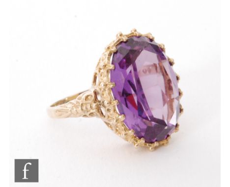 A modern 9ct hallmarked amethyst single stone ring, oval claw set amethyst, length 20mm, to a fancy basket head and ornate sh