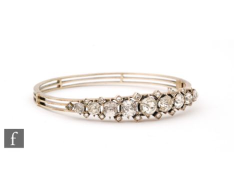 A 19th Century silver and paste set bangle, nine old cut stones with smaller matching smaller spacers to a pierced bangle, we