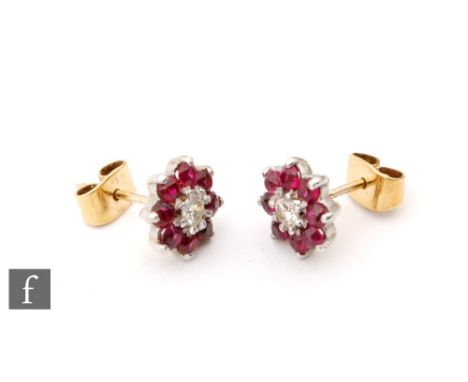 A pair of 9ct ruby and diamond cluster stud earrings, central brilliant cut diamond within eight stone ruby surround, all sto