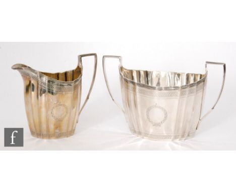 A Georgian hallmarked silver faceted boat shaped cream and sugar basin each with wiggle work borders and terminating in reede