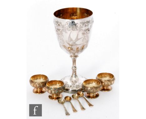 A Victorian hallmarked silver goblet with embossed and engraved foliate decoration, height 15cm, with a set of four silver gi