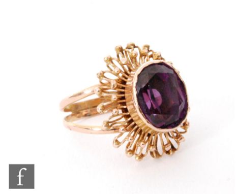 A 9ct amethyst single stone ring, oval collar set stones within a modernist gold shot border and split shoulders, ring size N