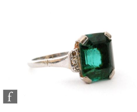 An 18ct white gold green tourmaline and diamond ring, central emerald cut tourmaline flanked by three diamonds to either side