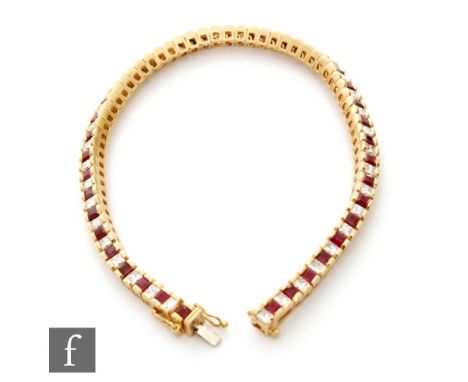 An 18ct hallmarked ruby and diamond tennis bracelet, seventy four alternating square cut channel set stones, terminating in t