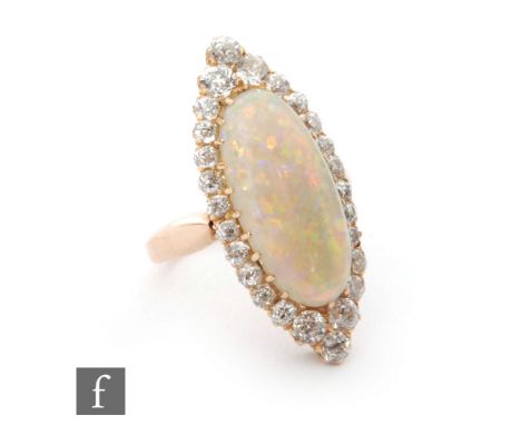 An early 20th Century 18ct opal and diamond ring, central oval opal, length 20mm, within a border of old and transitional cut