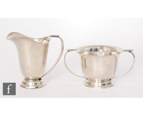 An American Sterling silver cream and sugar basin, stepped circular foot below plain bodies and stylised acanthus capped hand