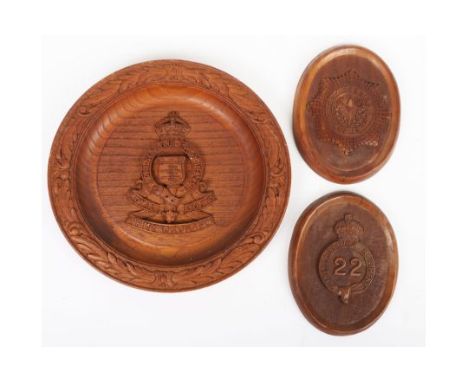 Carved Cheshire Regiment Plaques, two small oval wooden plaques carved with regimental badges and a carved wooden plate with 