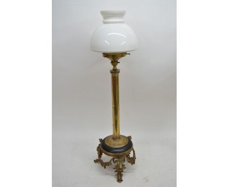 An early 20th Century table lamp with brass column, triple ram's head base and white glass shade, approx 81.5cm.