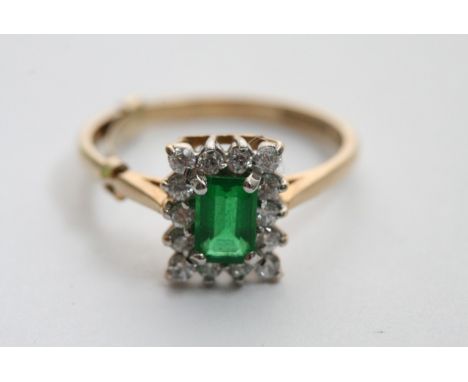 A 9ct gold ring set with an Emrald coloured stone flanked by CZ. 