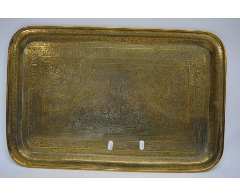 A large rectangular brass tray decorated in relief with Middle Eastern motifs, probably early 20th century. Approximately 58.