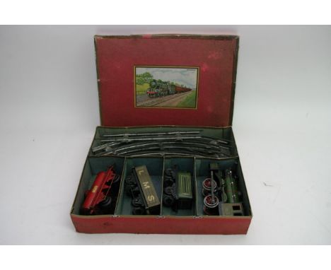 A boxed key wind Railway engine with Hornby 'OO' gauge wagons including Shell and LMS open wagon