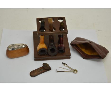 A pipe stand containing three Dunhill white spot pipes, a lighter and tobacco pouch