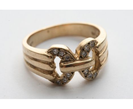 A 9ct gold ring set with cz stones in the form of a buckle