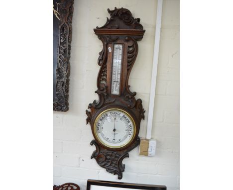 An oak carved barometer with applied thermometer box, Potts and sons Leeds