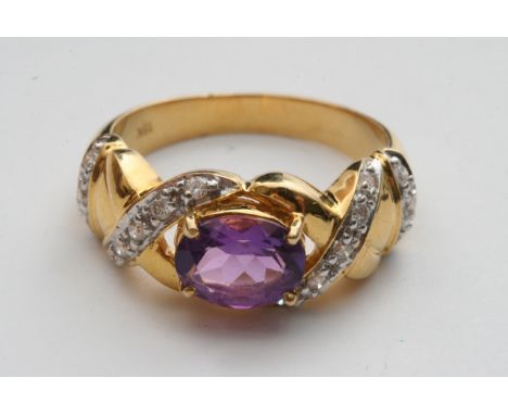 An 18ct gold Diamond and Amethyst and diamond ring the central oval stone flanked by rows of close woven diamonds.