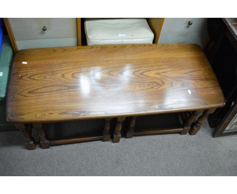 A nest of three Ercol type tables comprising of one long table and two smaller half sized tables, the large table measuring a
