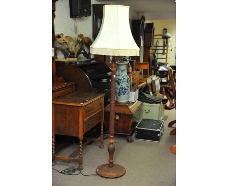 A carved wooden standard lamp.
