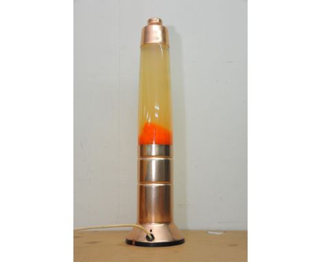 A rose gold coloured lava lamp with luminous orange coloured lava
