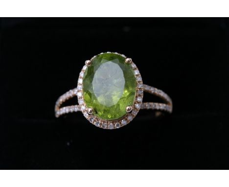 A yellow gold and diamond ring set with an oval cut peridot approx 4.41ct diamonds approx 0.40ct total weight