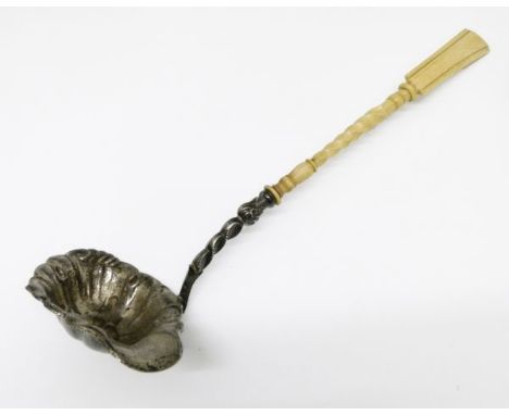 19th Century Continental white metal ladle, probably Austro-Hungarian, the bowl with embossed decoration and side lip, turned