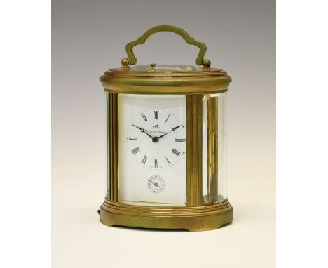 Matthew Norman brass cased oval repeater carriage clock, with white Roman main dial over subsidiary alarm dial, the lever pla