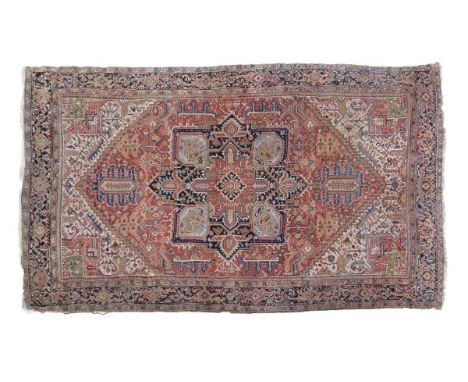 Caucasian wool carpet, the brick-red field with eight pointed star medallion within assorted flowers and foliage, the indigo 