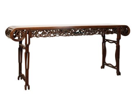 Chinese hardwood altar table, the cleated oblong top with carved scroll terminals, the intricately carved knotwork friezes, e