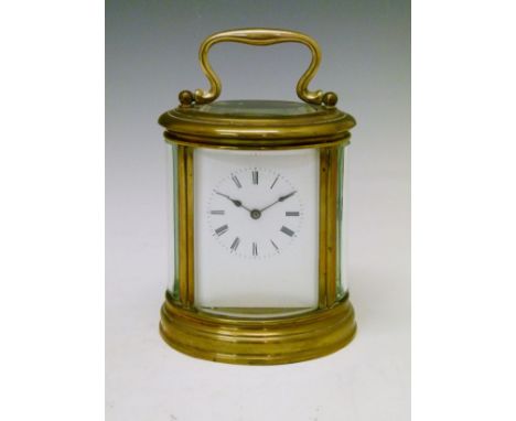 Large oval brass cased carriage clock, the white enamel dial with Roman numerals, movement with lever platform escapement str