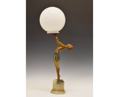 Art Deco design cold painted spelter figural table lamp formed as a lady dancer holding a white glass shade aloft, standing o
