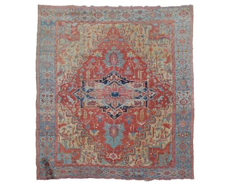 Large Caucasian wool carpet, the red field with central star medallion, within foliate designs, powder-blue polychrome border