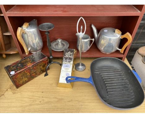 AN ASSORTMENT OF ITEMS TO INCLUDE A CAST IRON GRIDDLE PAN, PICQUOT WARE TEA AND COFFEE POTS AND A CANDLESTICK ETC 